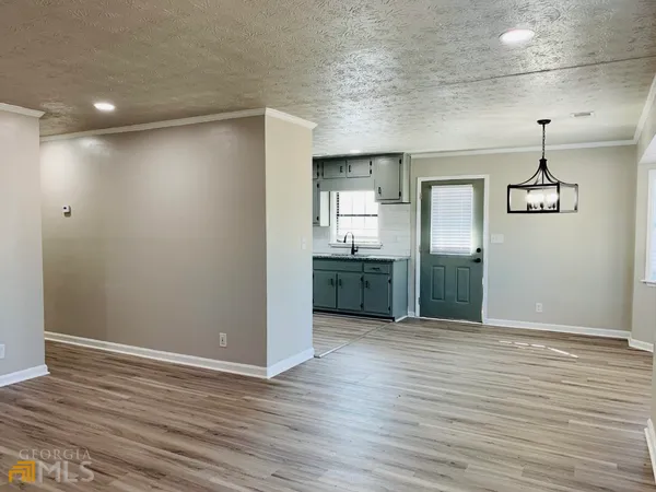 a view of a kitchen with a sink and wooden floor