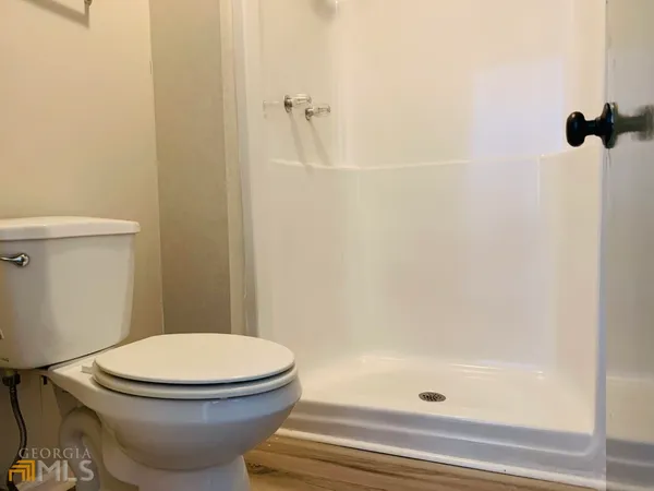 a white toilet sitting next to a bath tub and shower