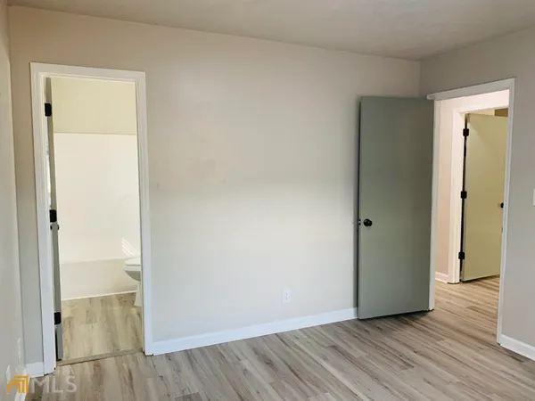 an empty room with wooden floor and doors
