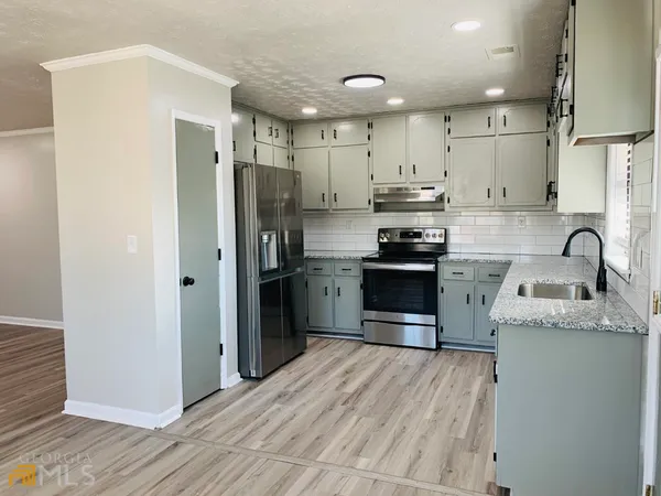 a kitchen with stainless steel appliances granite countertop a refrigerator sink and cabinets