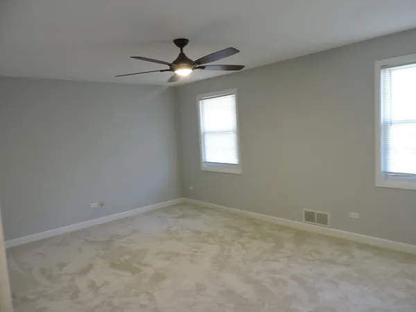 an empty room with a window and a fan