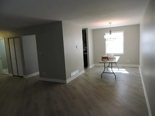 a view of a room with wooden floor lounge chair and windows