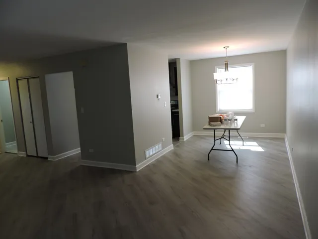 a view of a room with wooden floor lounge chair and windows