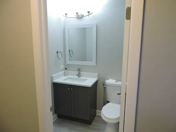a bathroom with a toilet a sink and mirror