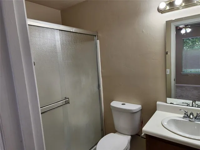 en empty room with windows and ceiling fan