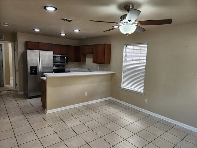 a kitchen with kitchen island white cabinets and stainless steel appliances