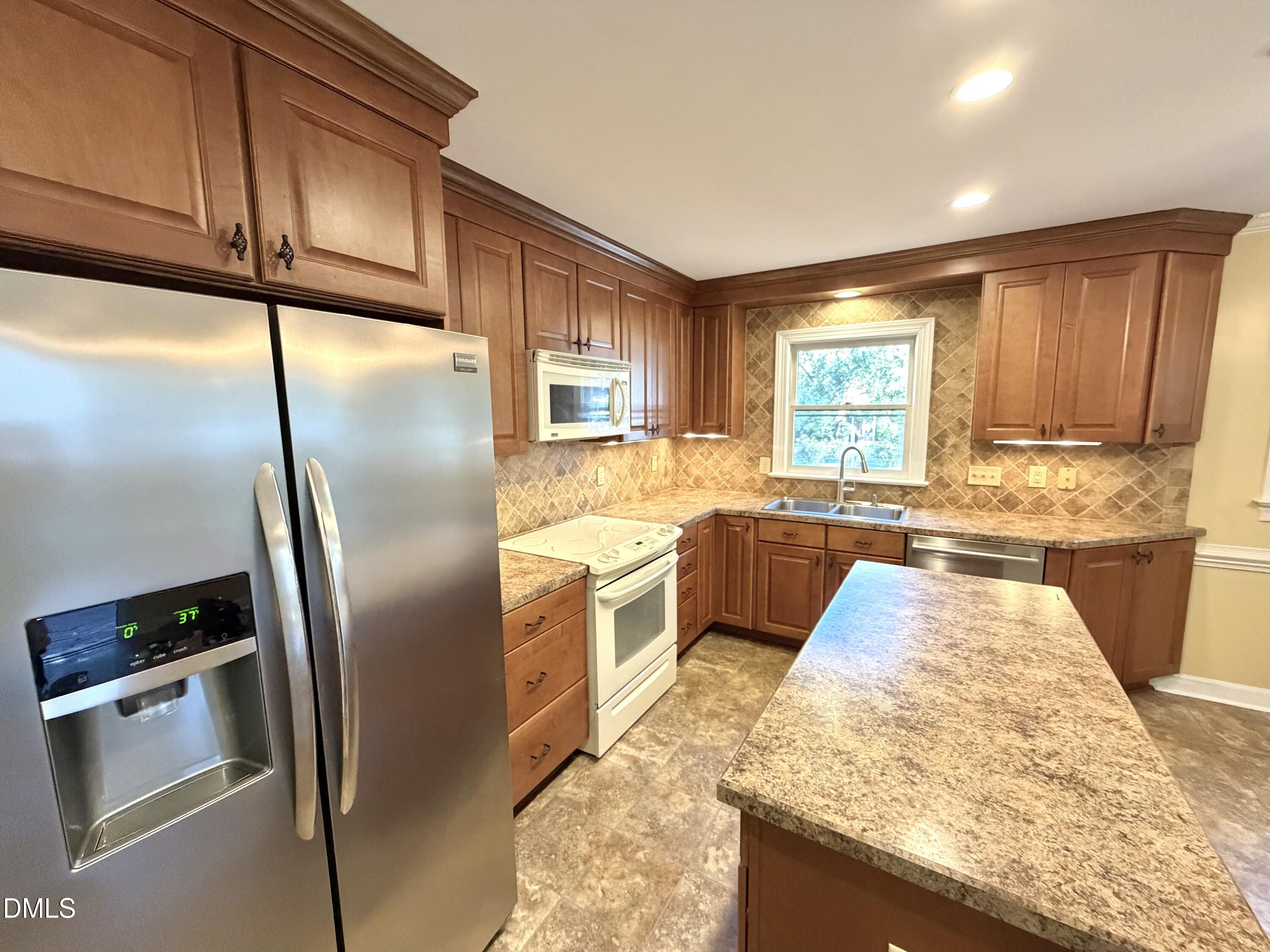 4907 Fortunes Ridge Drive Durham, NC 27713 - Photo 13 of 43 a kitchen with stainless steel appliances granite countertop a refrigerator a sink a stove and island