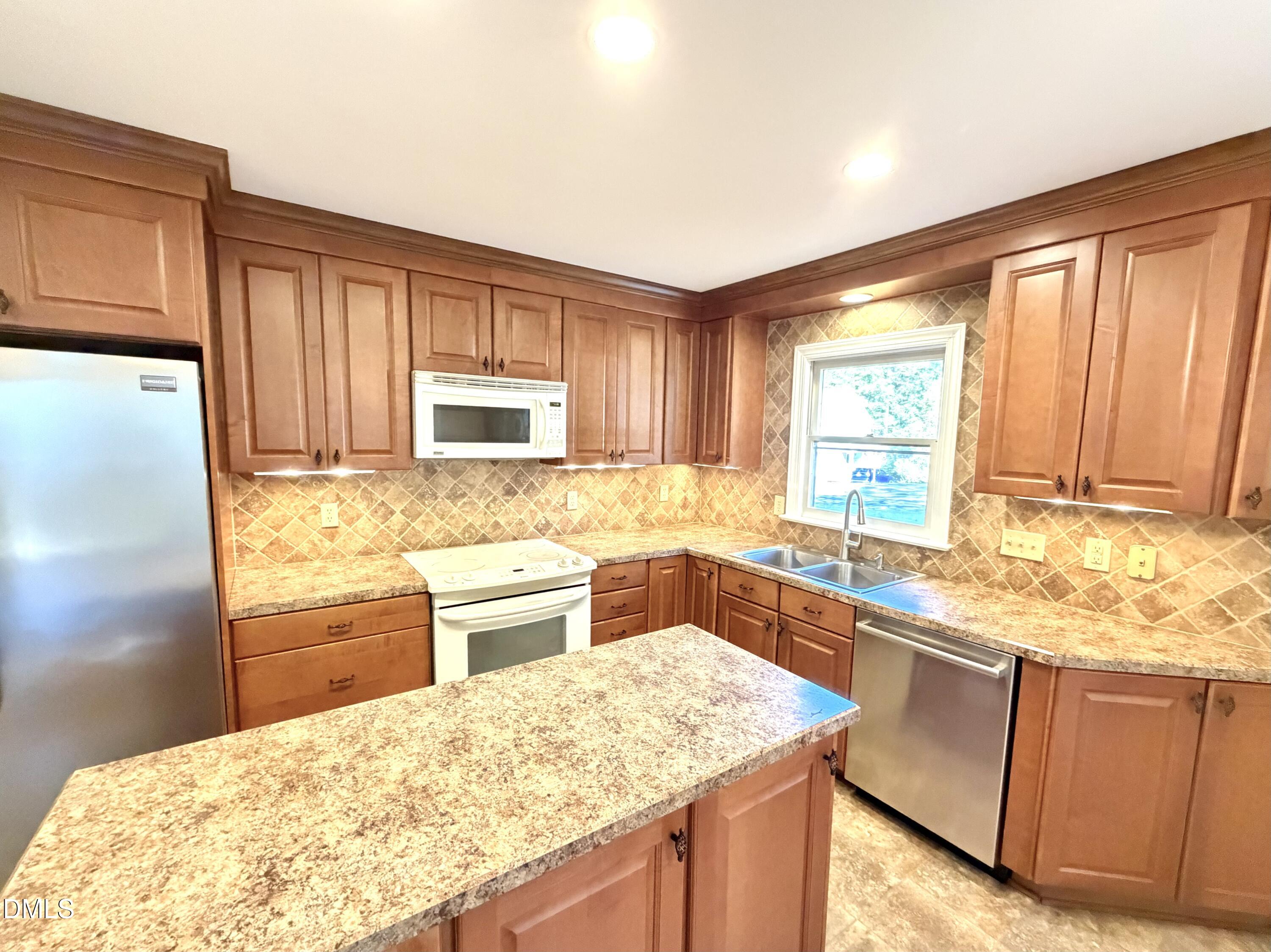 4907 Fortunes Ridge Drive Durham, NC 27713 - Photo 17 of 43 a kitchen with granite countertop cabinets stainless steel appliances a sink and a window