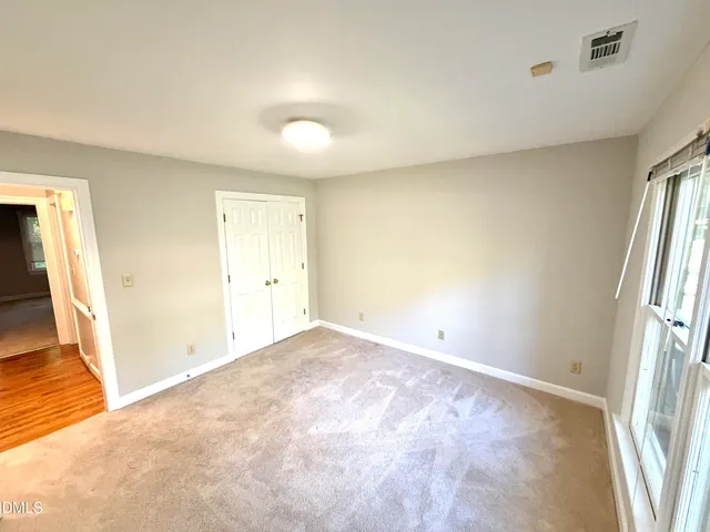 an empty room with a ceiling fan and a window