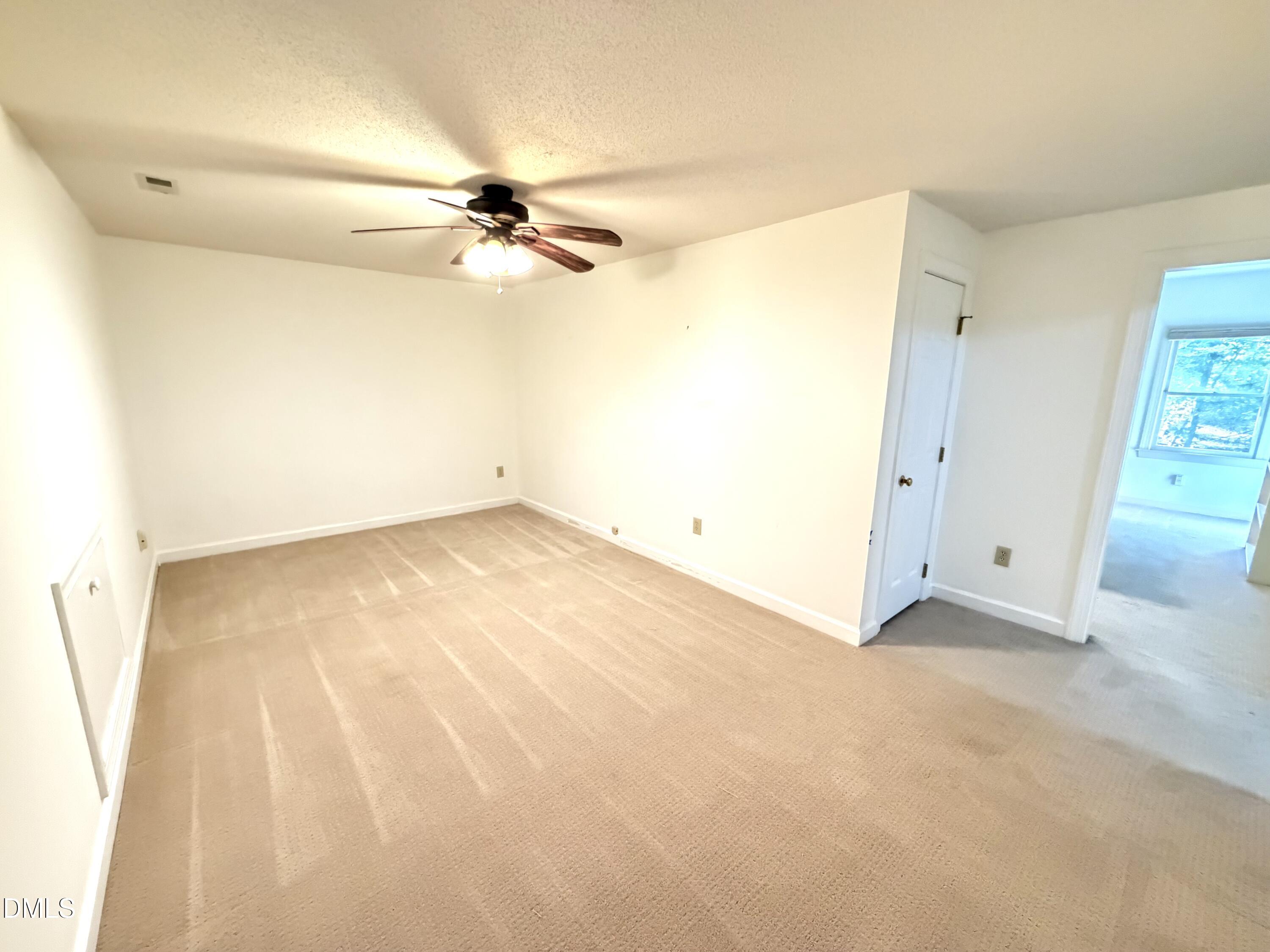 4907 Fortunes Ridge Drive Durham, NC 27713 - Photo 32 of 43 an empty room with a ceiling fan and a window