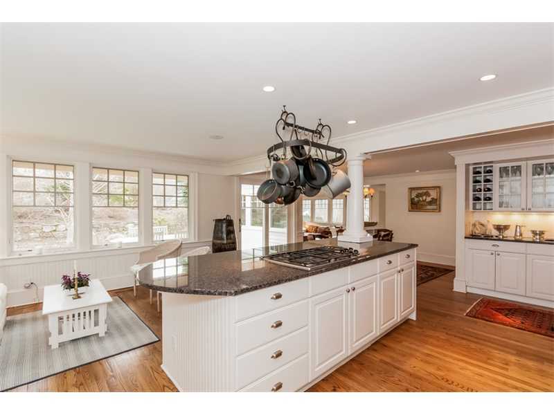 22 Indian Spring Road Rowayton, CT 06853 - Photo 7 of 23 a kitchen with granite countertop a stove a sink and white cabinets with wooden floor