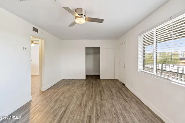 a view of a kitchen with a fridge and wooden floor