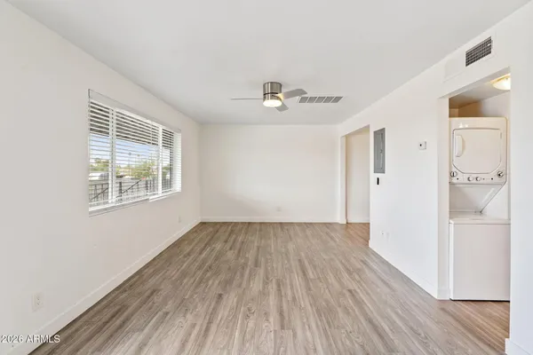 a view of an empty room with wooden floor and a window