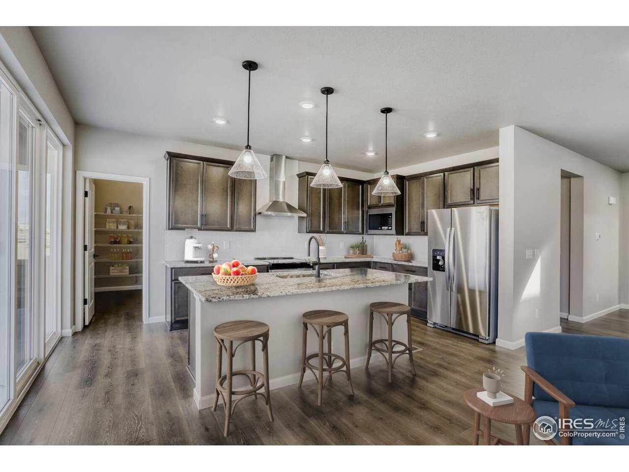 662 Noola Street Windsor, CO 80550 - Photo 4 of 29 a kitchen with stainless steel appliances kitchen island a refrigerator a stove a sink dishwasher with a dining table and chairs