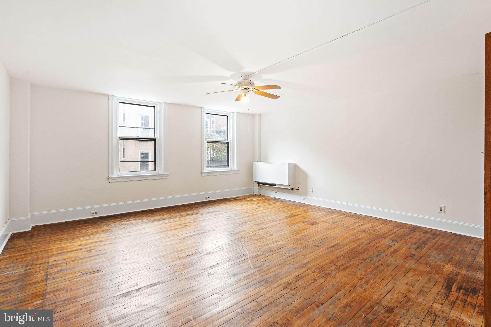 1008 Spruce Street, Unit 21 Philadelphia, PA 19107 - Photo 4 of 16 an empty room with wooden floor and windows