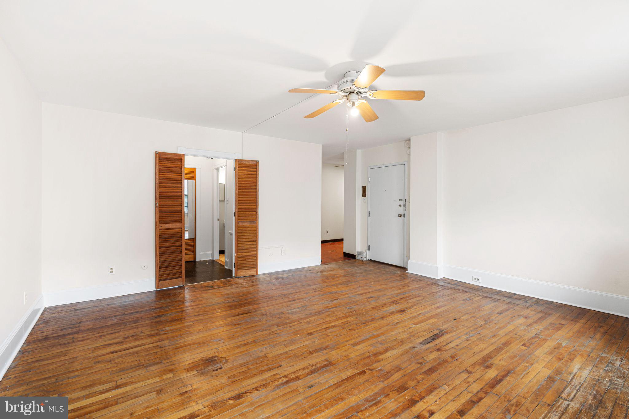 1008 Spruce Street, Unit 21 Philadelphia, PA 19107 - Photo 5 of 16 a view of an empty room with window and wooden floor