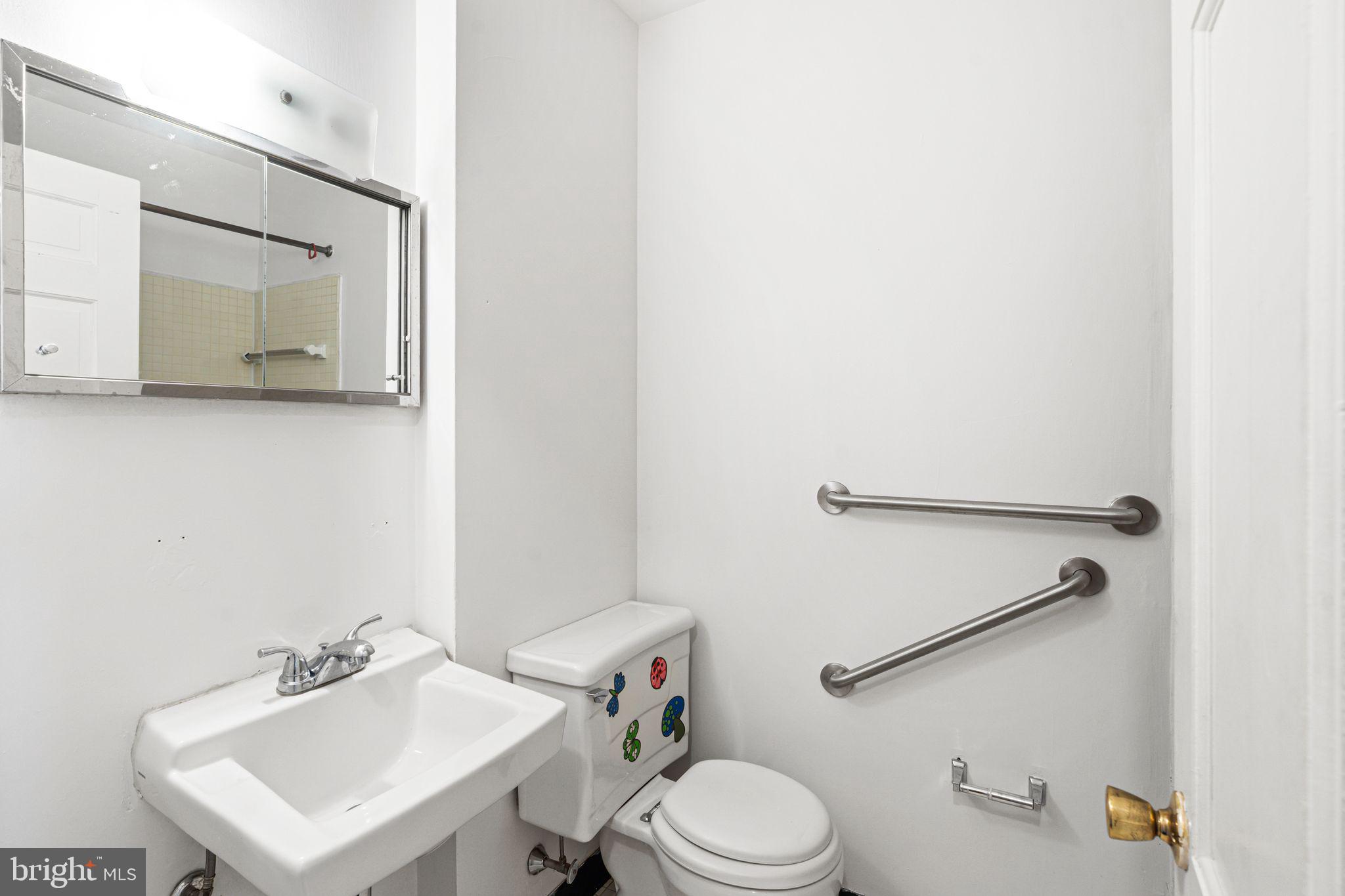 1008 Spruce Street, Unit 21 Philadelphia, PA 19107 - Photo 10 of 16 a bathroom with a toilet a sink and mirror
