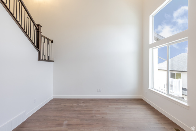 4816 Heartwood Road, Unit 423 Mapleton, UT 84664 - Photo 11 of 21 Empty room featuring dark wood-style floors and a high ceiling