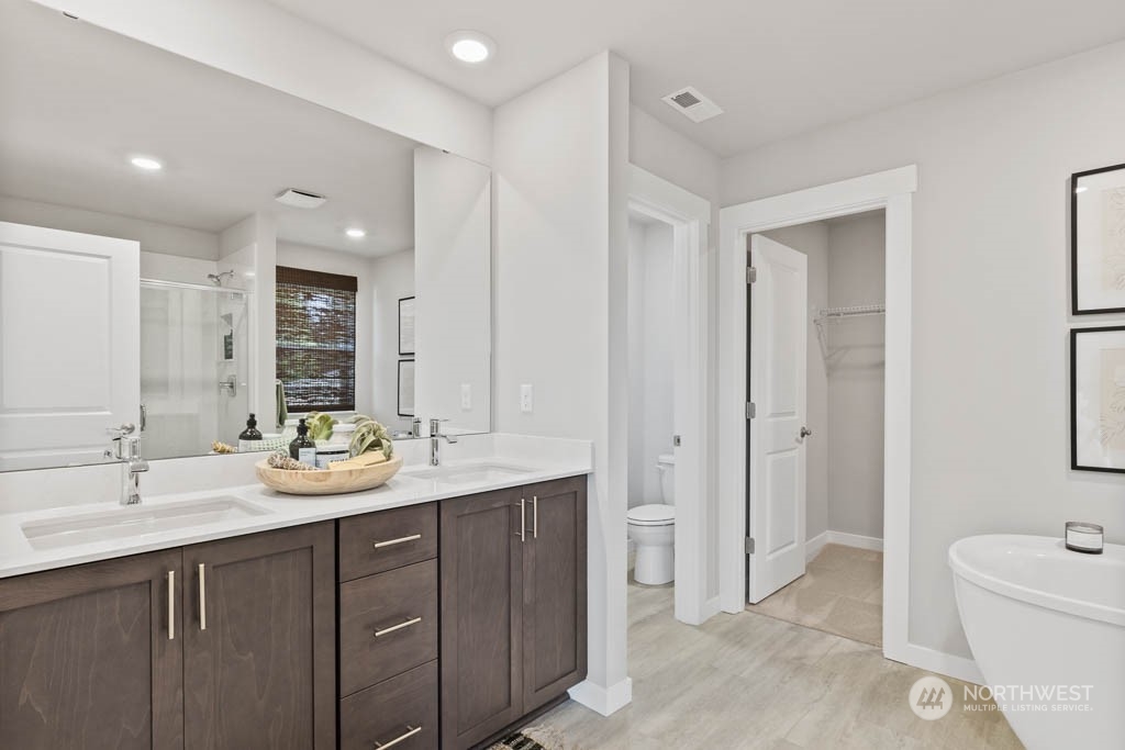616 185th Street Southwest, Unit NCV24 Bothell, WA 98012 - Photo 21 of 25 a spacious bathroom with a double vanity sink mirror and toilet