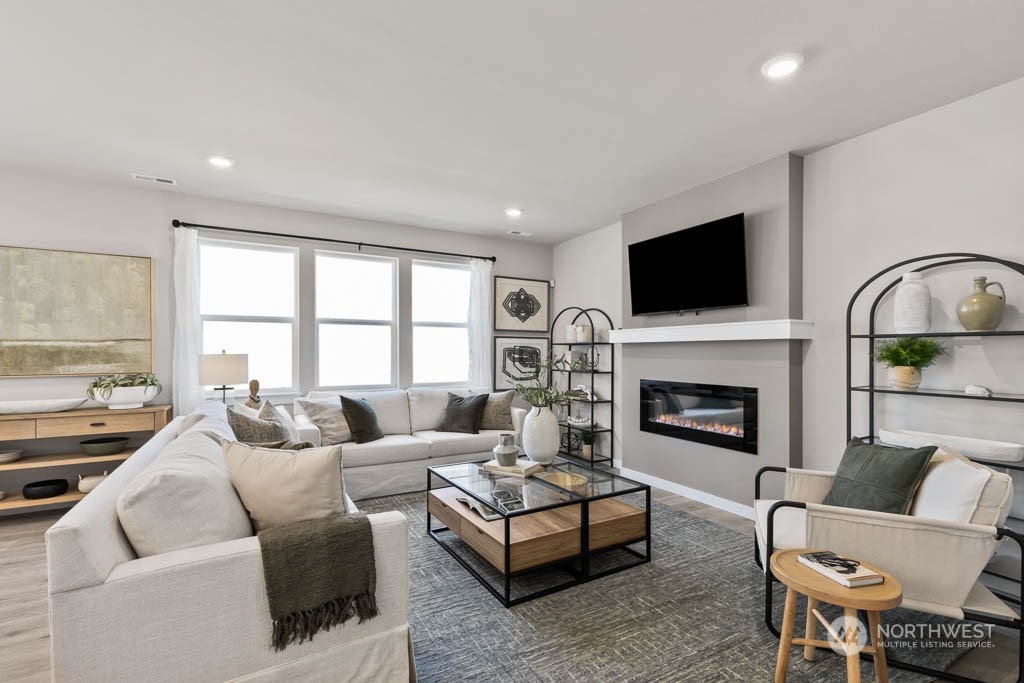 616 185th Street Southwest, Unit NCV24 Bothell, WA 98012 - Photo 6 of 25 a living room with furniture flat screen tv and a fireplace