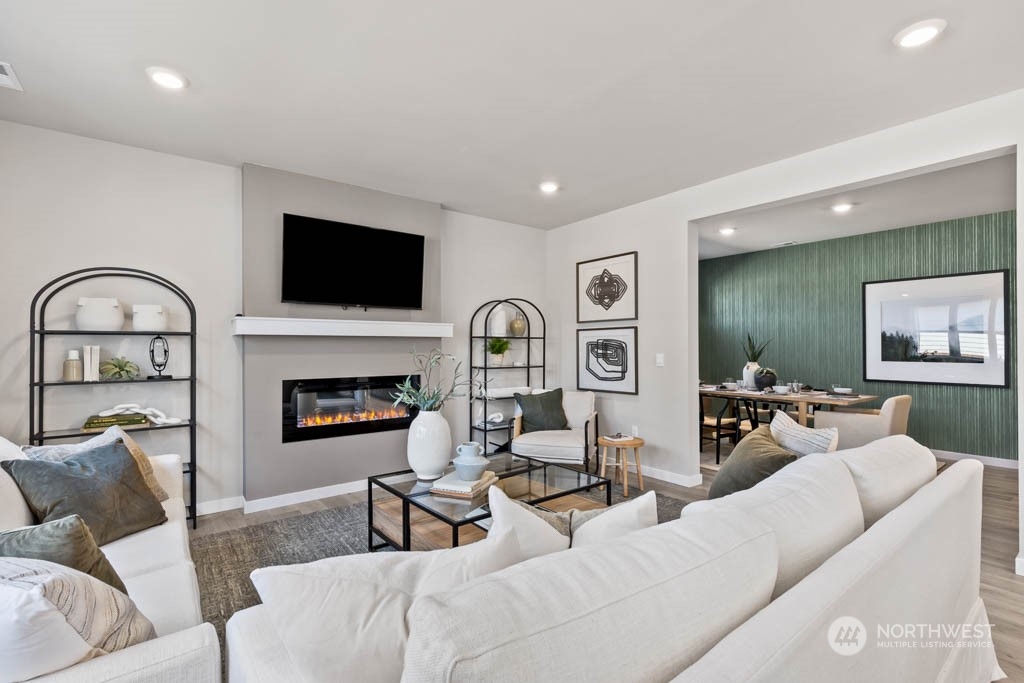 616 185th Street Southwest, Unit NCV24 Bothell, WA 98012 - Photo 7 of 25 a living room with furniture a fireplace and a flat screen tv