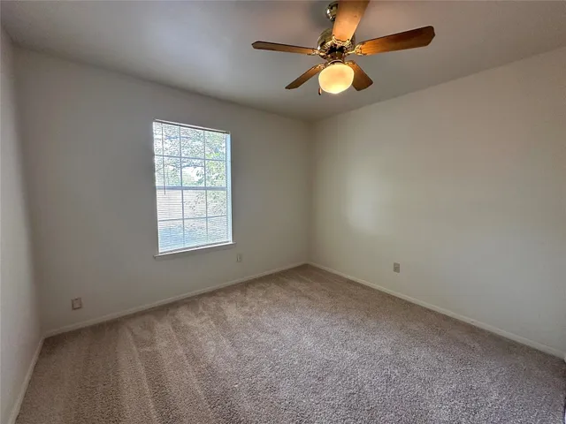 a view of a backyard with wooden fence and a bench