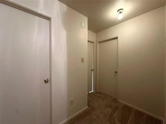 an empty room with windows and ceiling fan
