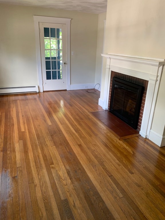 4 Martin Street, Unit 1 Marblehead, MA 01945 - Photo 2 of 13 wooden floor fireplace and windows in an empty room