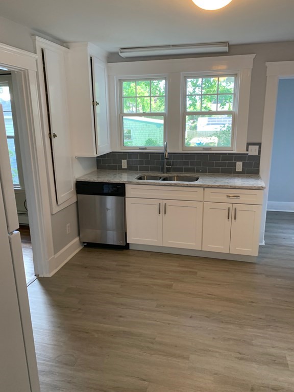 4 Martin Street, Unit 1 Marblehead, MA 01945 - Photo 4 of 13 a kitchen with stainless steel appliances granite countertop a stove a sink and a refrigerator
