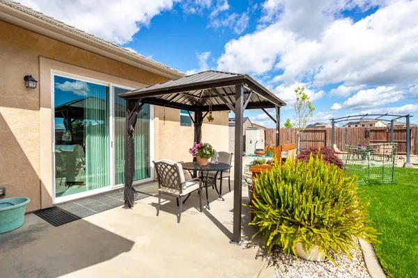 a roof deck with table and chairs and potted plants