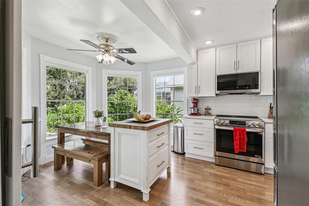 7115 Hummingbird Lane New Port Richey, FL 34655 - Photo 30 of 75 a kitchen with stainless steel appliances a stove a sink and a microwave