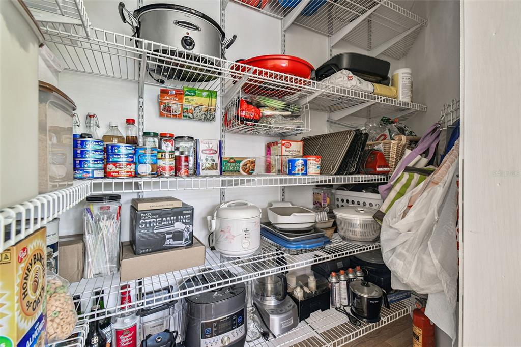 7115 Hummingbird Lane New Port Richey, FL 34655 - Photo 33 of 75 a store room with stainless steel appliances and a wooden floor