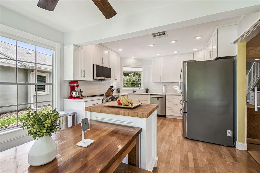 7115 Hummingbird Lane New Port Richey, FL 34655 - Photo 5 of 75 a kitchen with stainless steel appliances granite countertop a refrigerator a stove and a wooden floors
