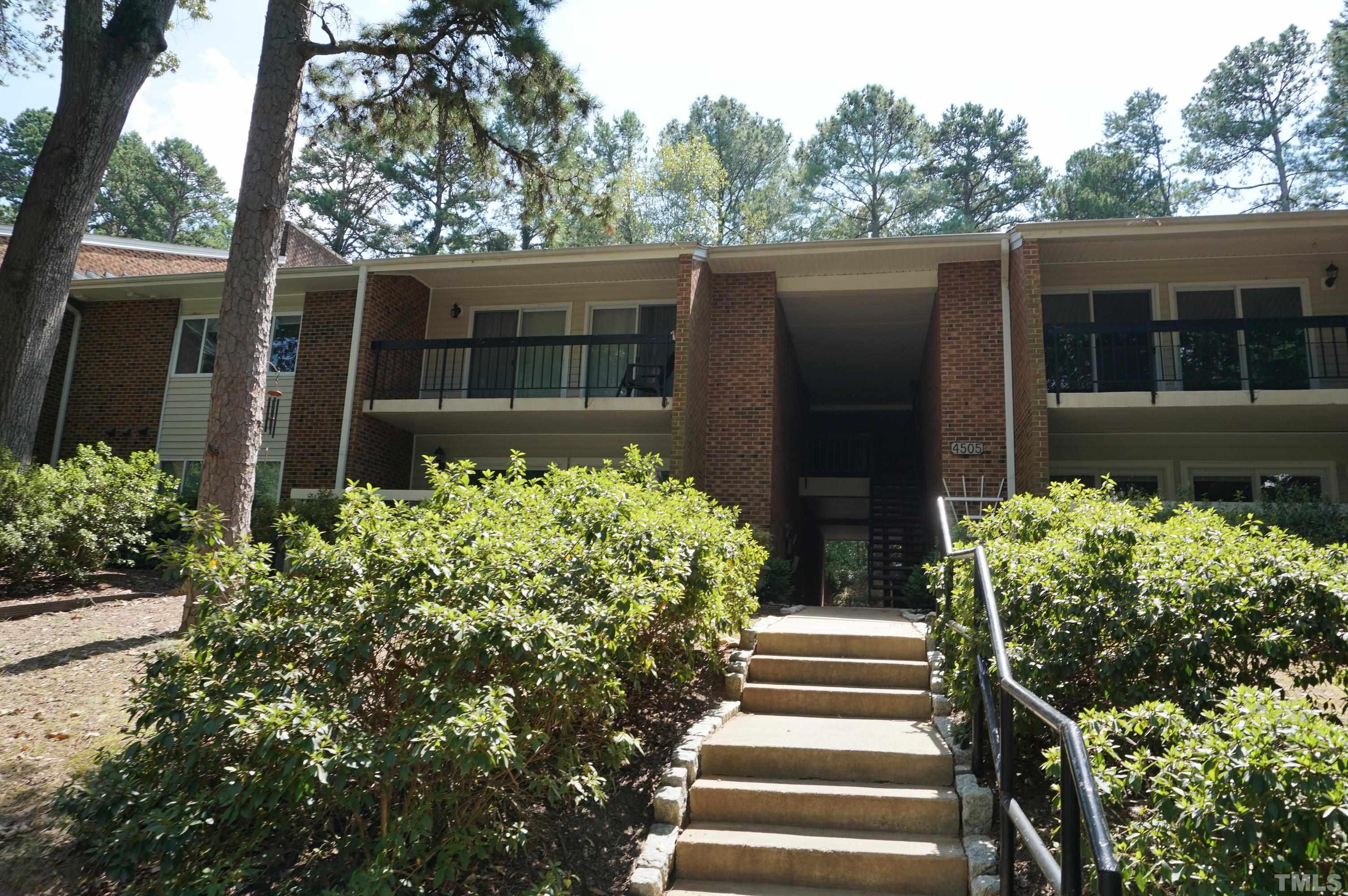 4505 Edwards Mill Road, Unit F Raleigh, NC 27612 - Photo 1 of 34 a view of a house with potted plants and a bench