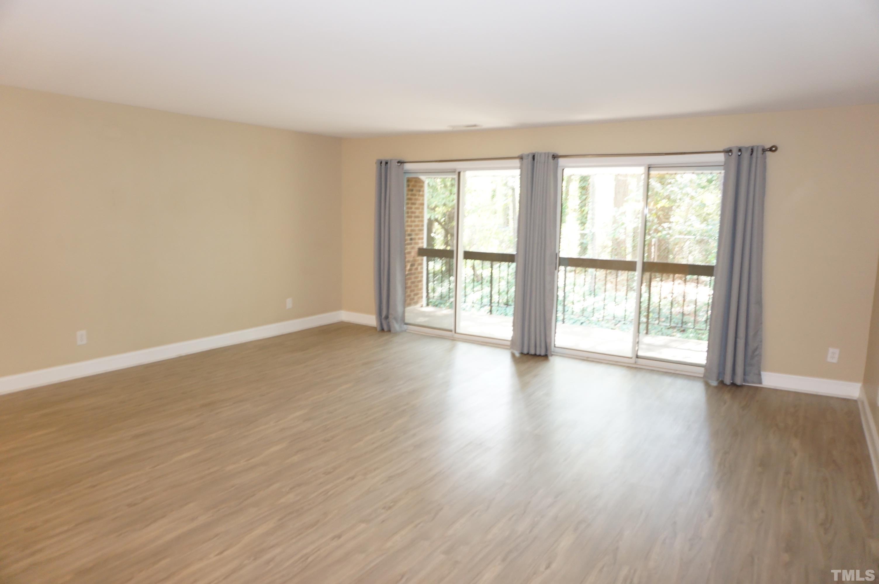 4505 Edwards Mill Road, Unit F Raleigh, NC 27612 - Photo 11 of 34 a view of an empty room with wooden floor and a window