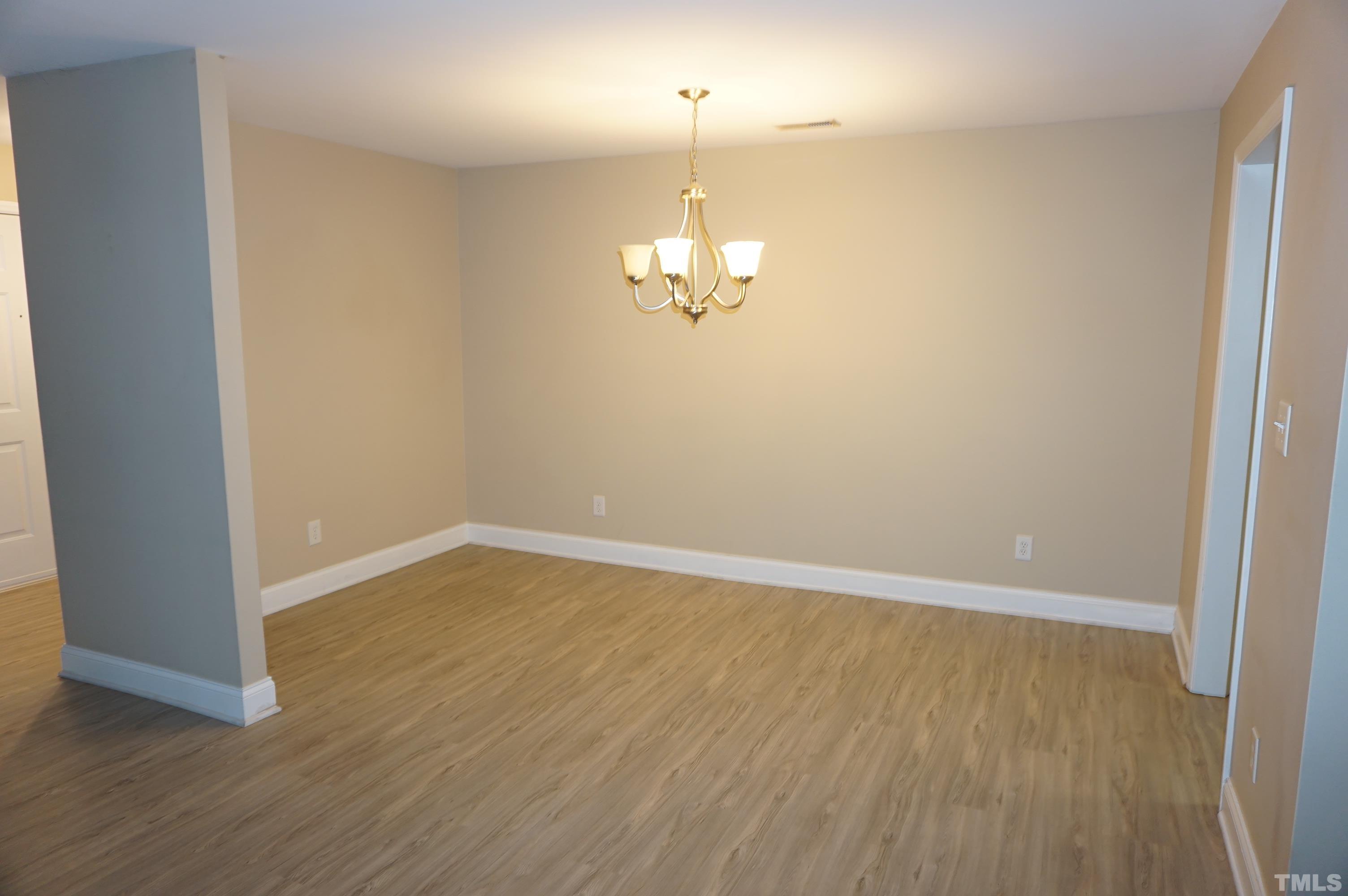 4505 Edwards Mill Road, Unit F Raleigh, NC 27612 - Photo 15 of 34 wooden floor in an empty room with a mirror