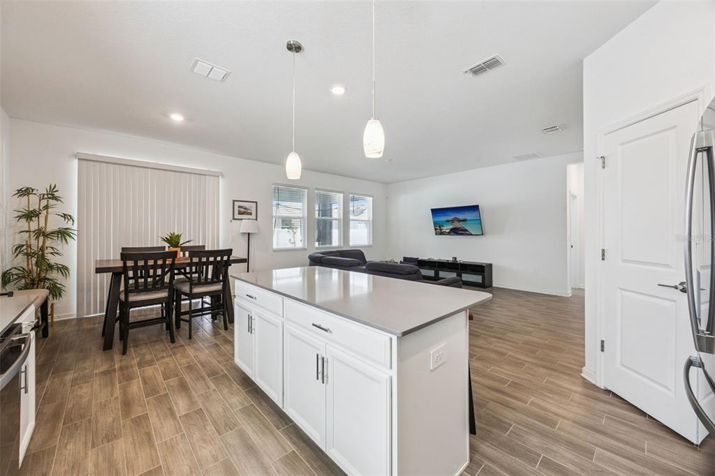 2714 Slash Way St. Cloud, FL 34771 - Photo 18 of 50 a large kitchen with kitchen island a wooden floor and white cabinets