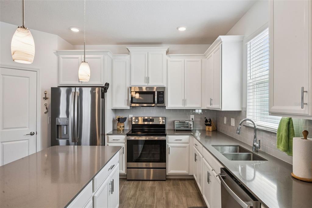 2714 Slash Way St. Cloud, FL 34771 - Photo 20 of 50 a kitchen with granite countertop a sink a counter space stainless steel appliances and cabinets
