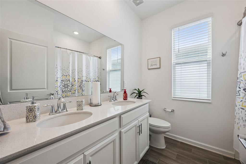 2714 Slash Way St. Cloud, FL 34771 - Photo 25 of 50 a bathroom with a double vanity sink toilet and a mirror