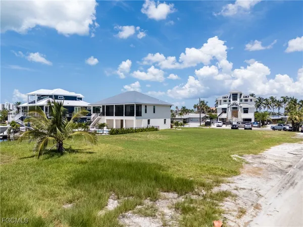 a front view of a house with a garden and lake view