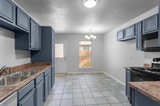 a kitchen with a stove a sink and a microwave