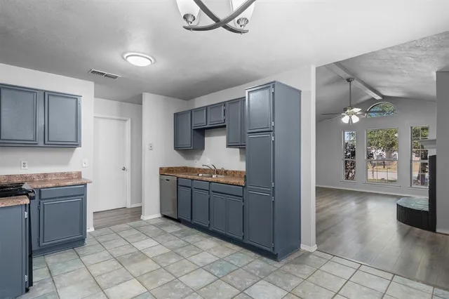 a kitchen with granite countertop a refrigerator and a stove top oven