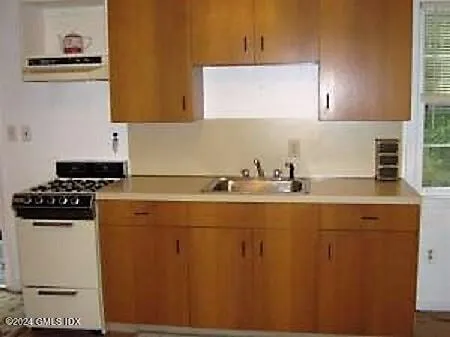 a kitchen with sink a stove and cabinets