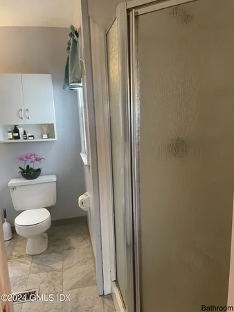 a bathroom with a toilet and a shower
