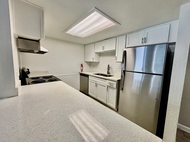 a kitchen with stainless steel appliances a refrigerator sink and cabinets
