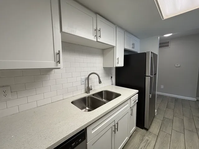 a kitchen with stainless steel appliances a refrigerator sink and cabinets
