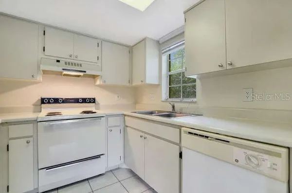 a kitchen with cabinets appliances a sink and a window