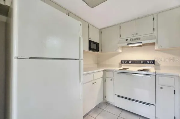 a kitchen with cabinets and white stainless steel appliances