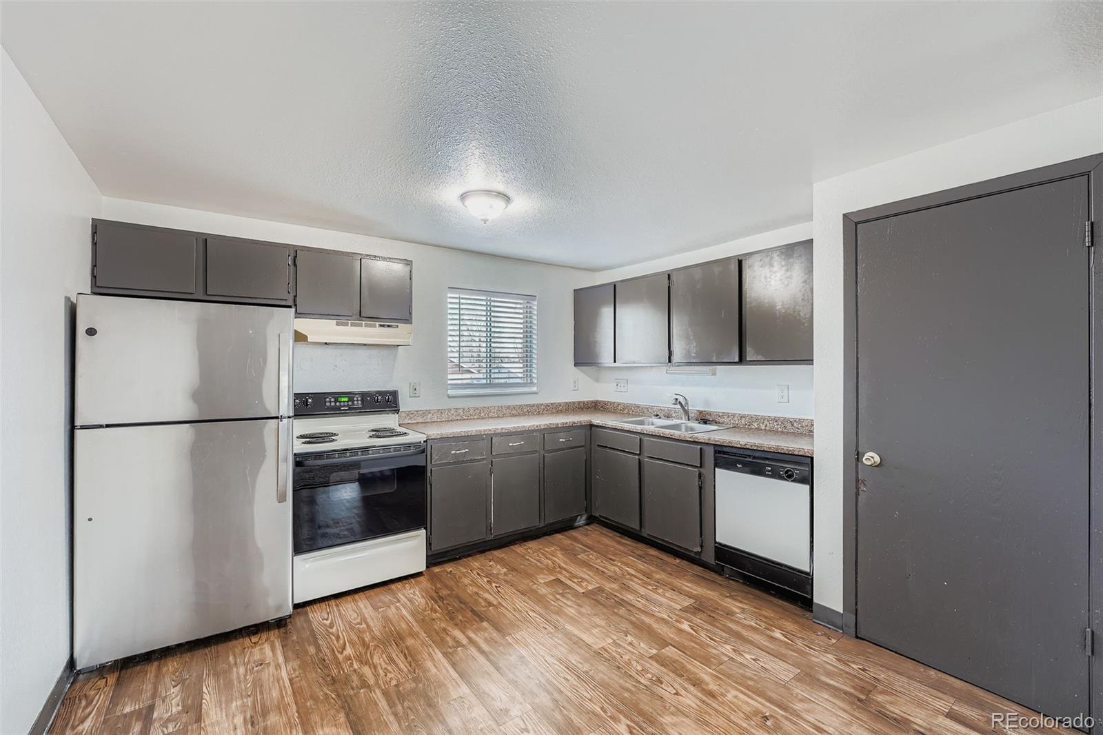 1080 South Eliot Street, Unit 203 Denver, CO 80219 - Photo 4 of 13 a kitchen with a refrigerator sink and stove top oven