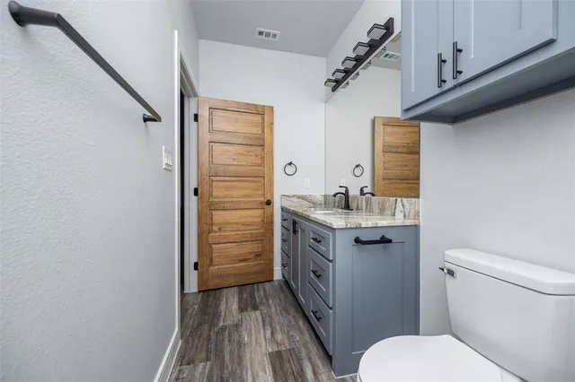 a bathroom with a granite countertop toilet a sink and bathtub